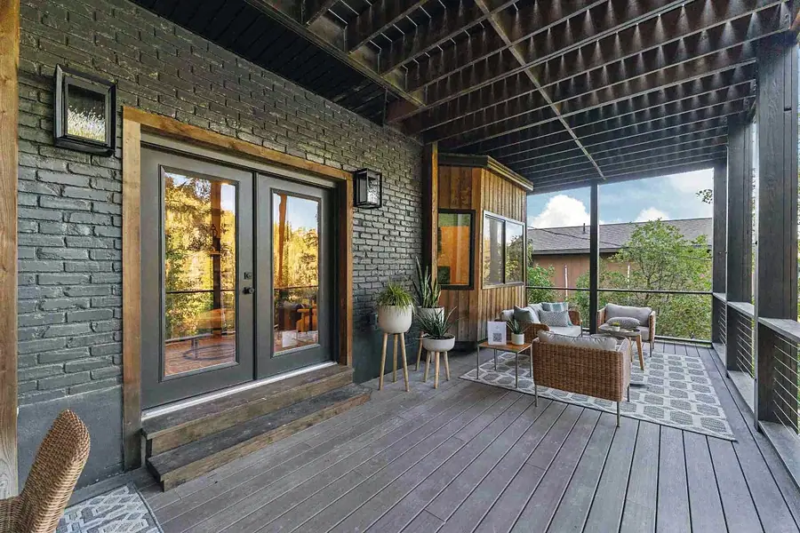 Matterhorn Hygge House covered deck with French doors, brick exterior, and outdoor lounge seating