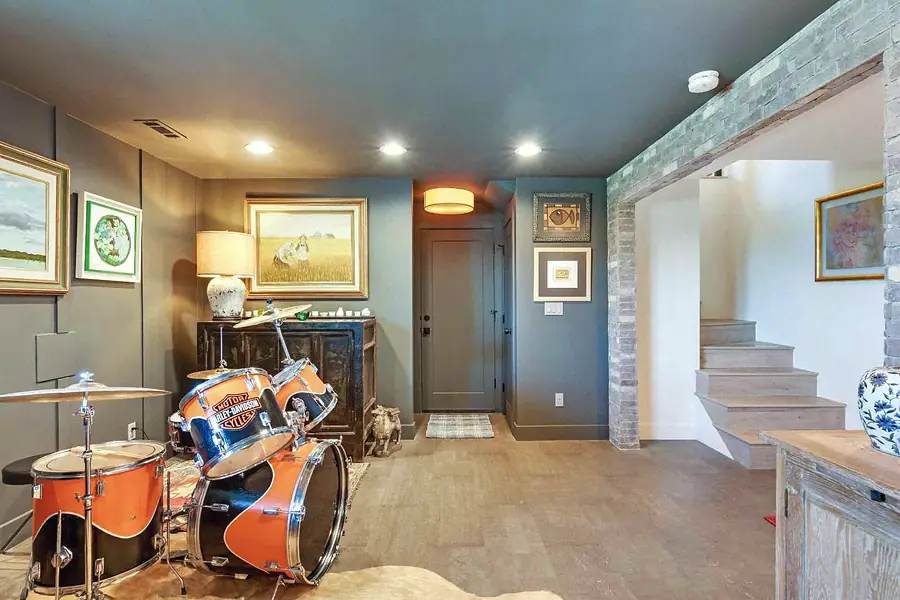 Wallace Project lower level with drum kit, art, and brick archway