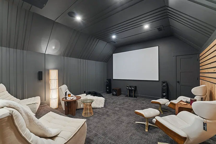 Matterhorn Hygge House home theater with projection screen, lounge chairs, and charcoal walls