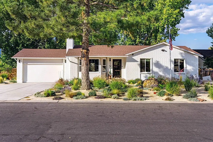 Midway front exterior white brick ranch with pine tree, xeriscape garden, and house number 19