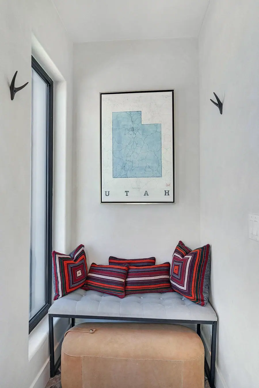 Entry nook with Utah map art, striped pillows, and tufted bench