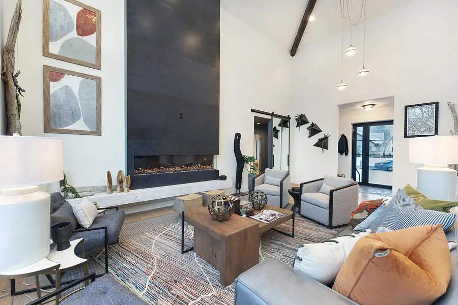 Living room looking toward the entry with fireplace and pendant lights