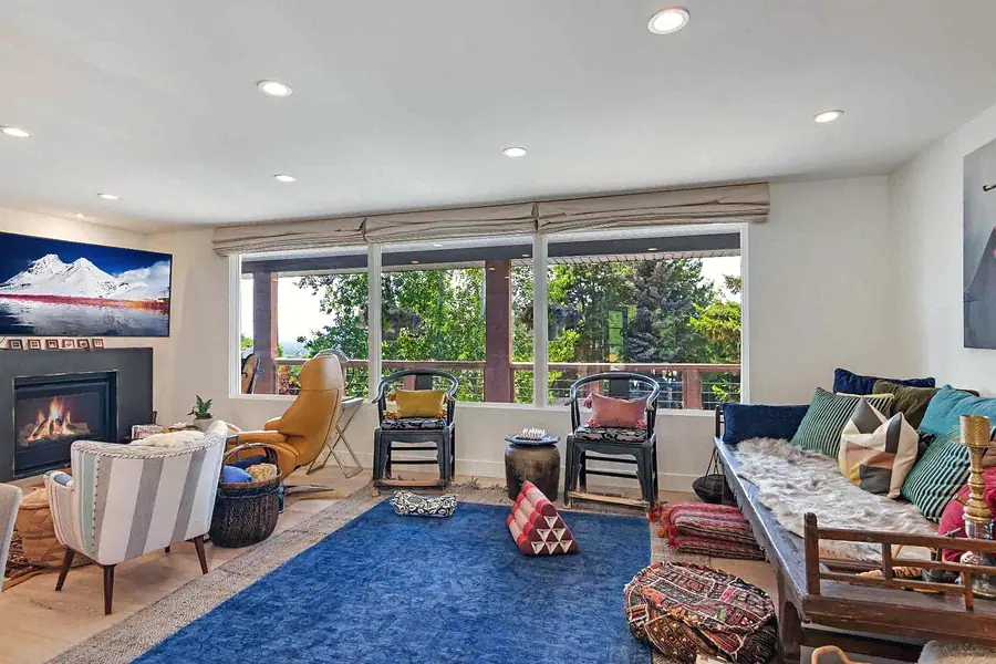 Wallace Project living room with blue rug, fireplace, and garden views