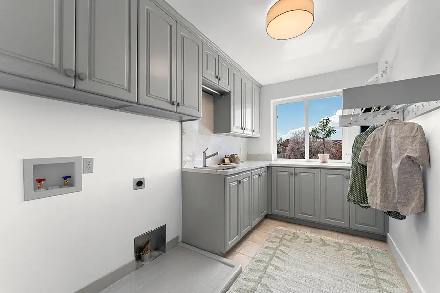 Grand Vista laundry room with gray cabinetry, folding counter, and drying rack