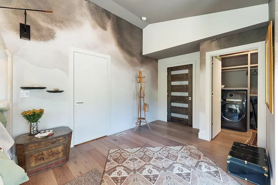 Elysium primary suite hall with laundry closet and watercolor mural wall