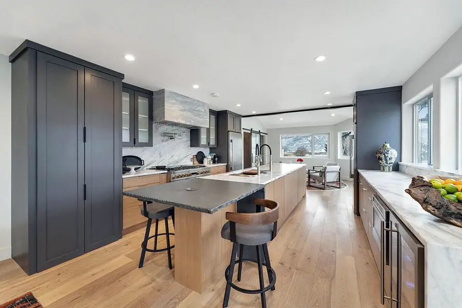 Chef’s kitchen with dual-tone island, marble, and dark cabinetry