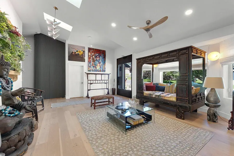 Elysium living room with carved wood daybed, glass coffee table, and skylights
