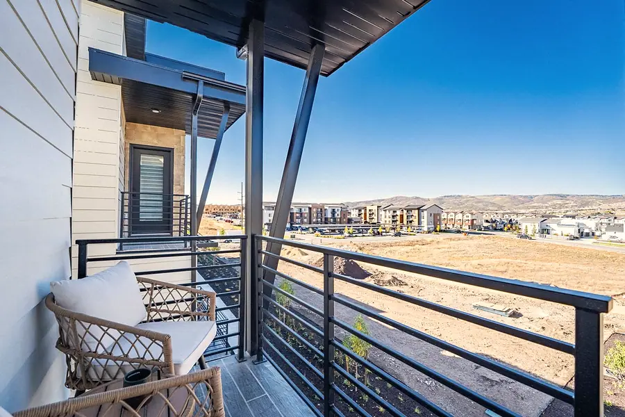 Silver Creek covered balcony with woven chairs overlooking the development and hills