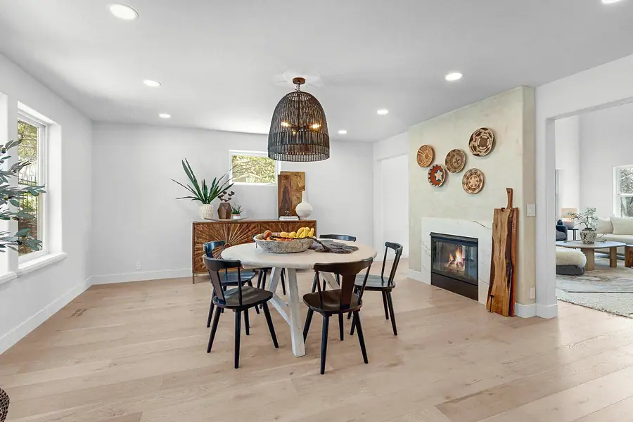 Grand Vista dining room with round table, woven pendant, and fireplace