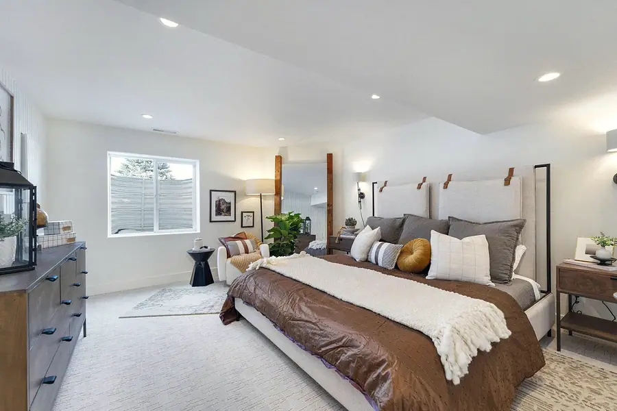 Primary bedroom with dual upholstered headboards, brown bedding, and seating nook