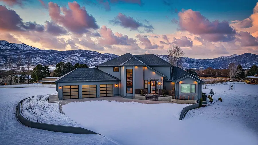 Le Petit Chateau at dusk with glowing garage lights and pink mountain sky