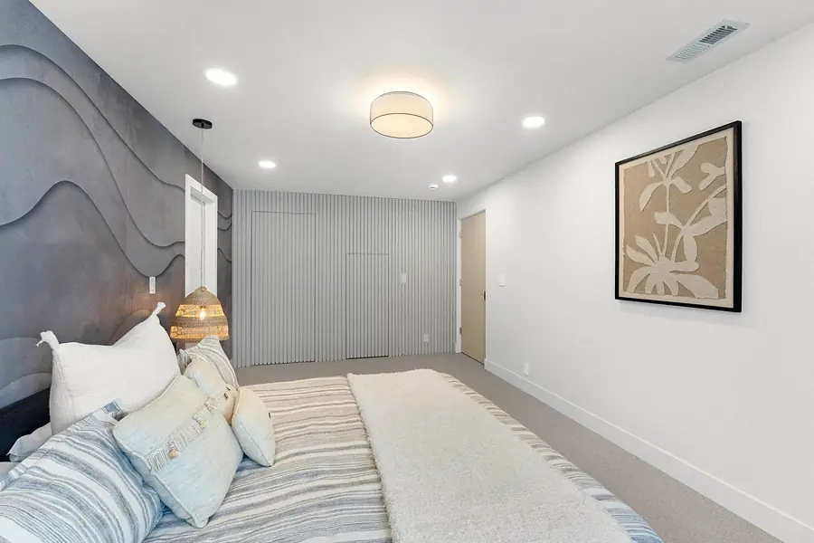 Grand Vista bedroom looking toward fluted closet wall and botanical art