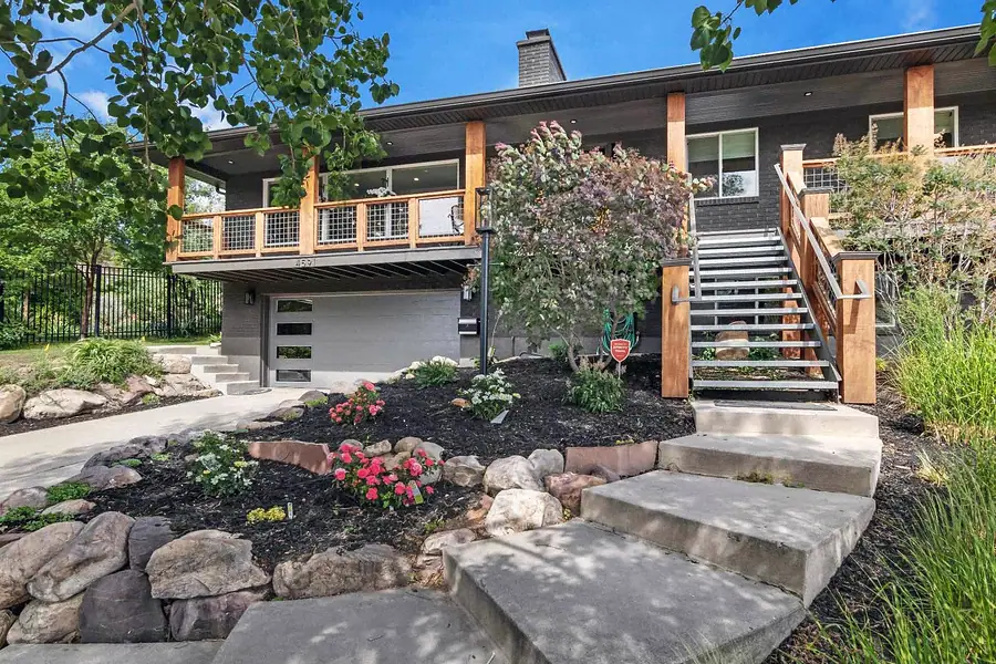 Wallace Project exterior with wood deck, metal stairs, and landscaped entry, Holladay, Utah