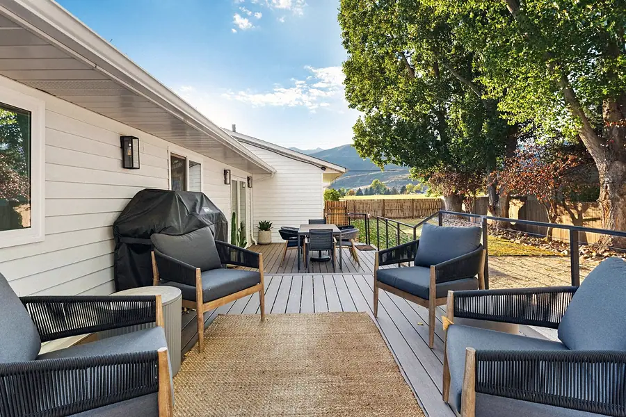 Midway deck lounge seating with blue cushions, jute rug, and mountain views