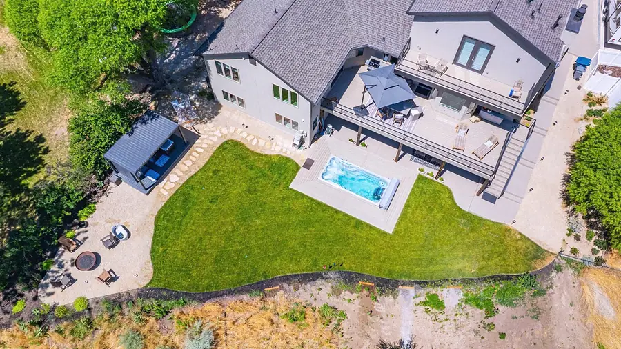 Elysium aerial view of backyard lawn, spa, decks, and outdoor lounge