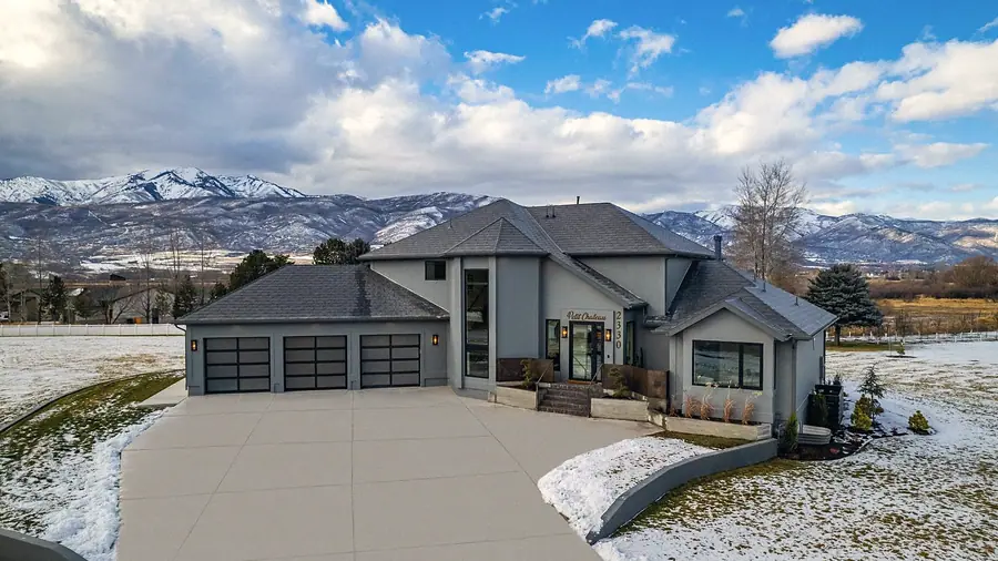 Le Petit Chateau exterior with three-car garage and snow-capped mountains, Heber City, Utah