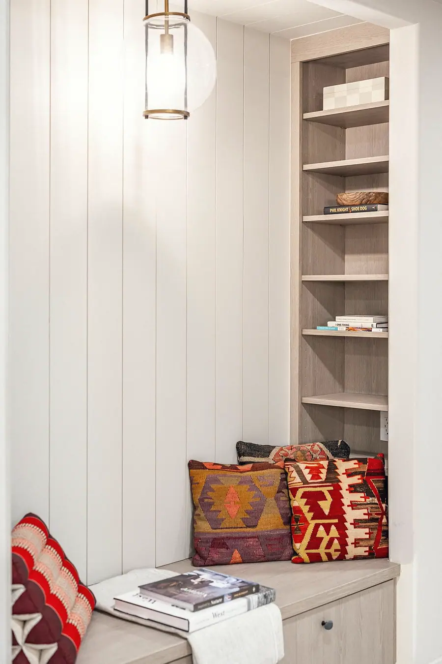Grand Vista reading nook with open shelves, books, and patterned throw pillows