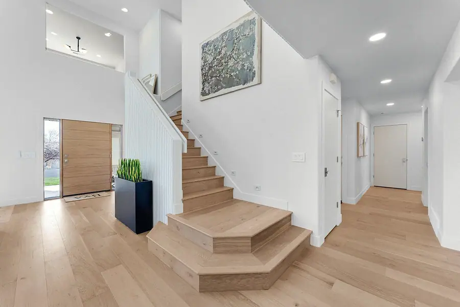 Grand Vista entry foyer with oak stairs and wood front door
