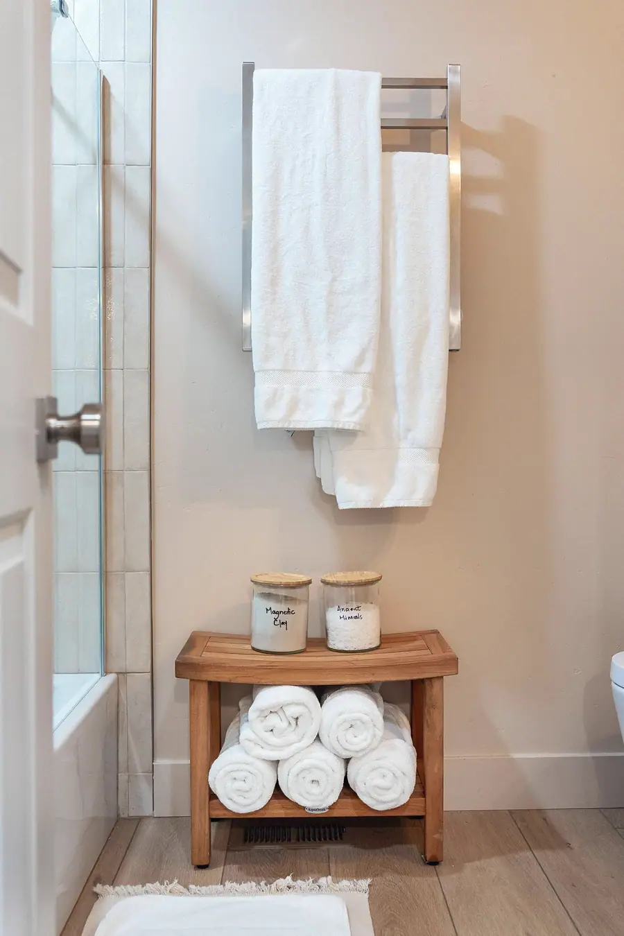Midway bathroom with white towels, wood towel shelf, and warm neutral finishes