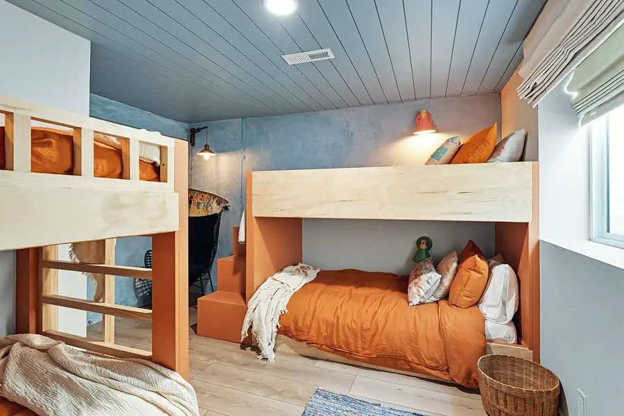 Midway bunk room with twin orange built-ins, blue ceiling, and terracotta bedding