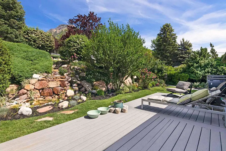 Wallace Project wood deck overlooking a landscaped rock waterfall garden