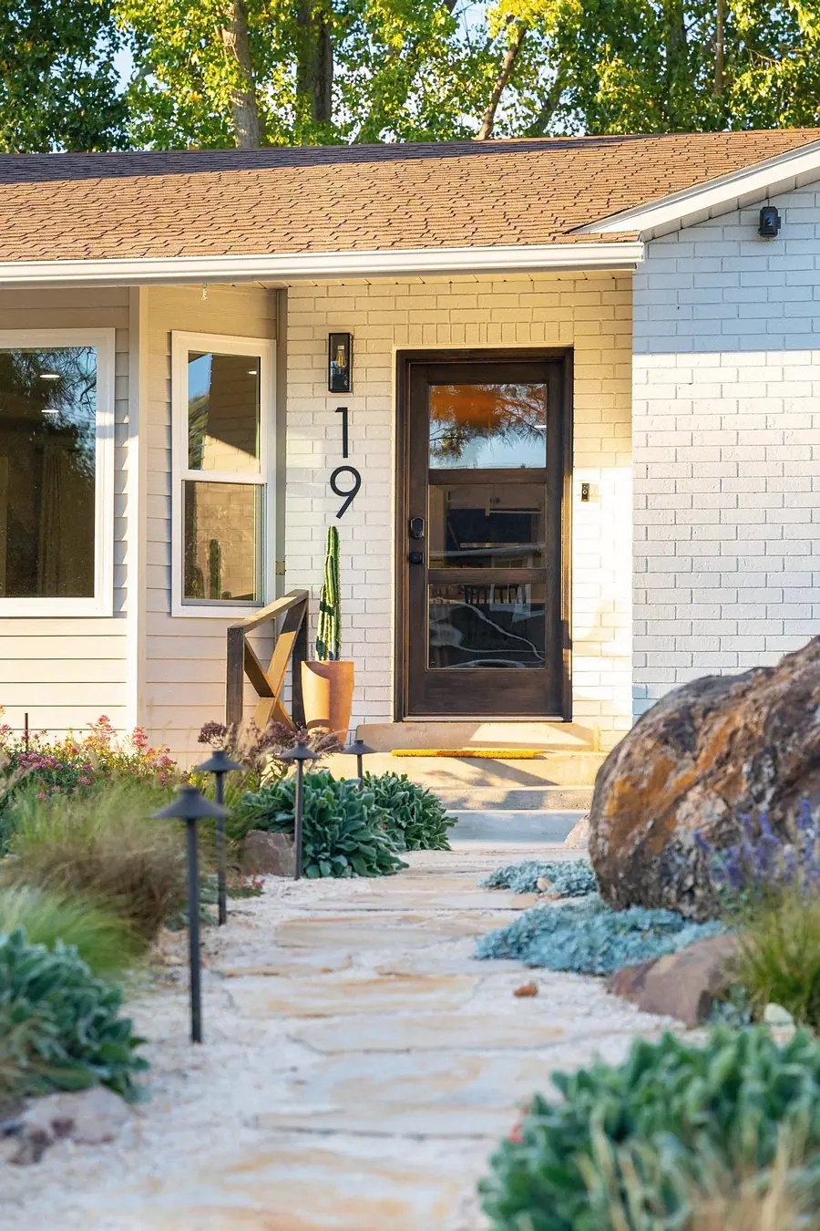 Midway entry path with flagstone walkway leading to dark wood door numbered 19