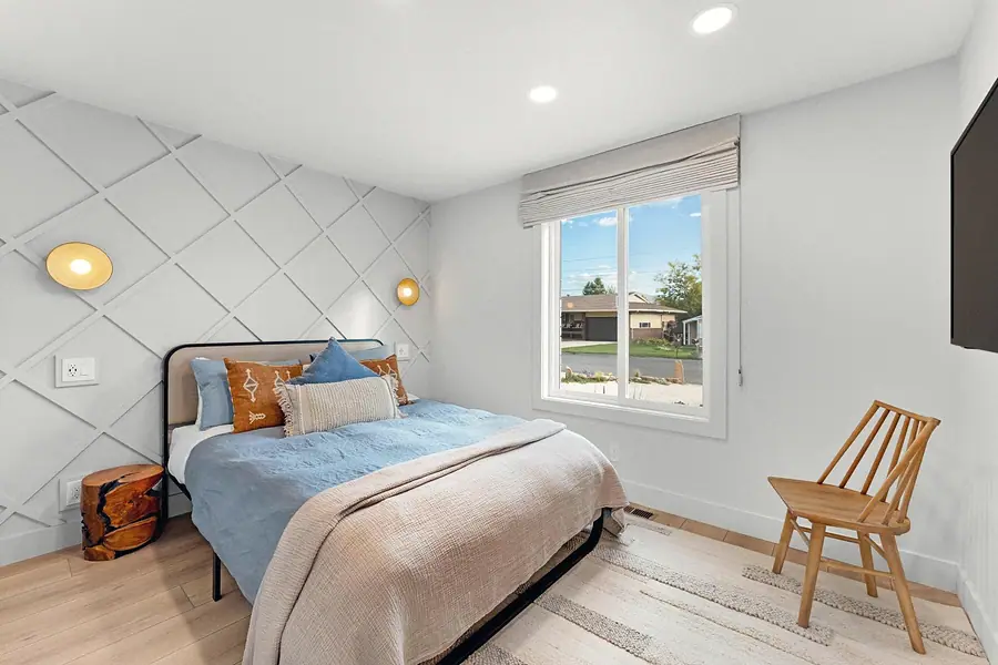Midway guest bedroom with diamond wall molding, blue bedding, and wood chair