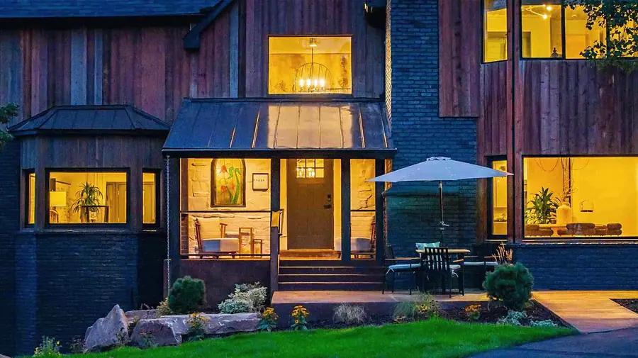 Matterhorn Hygge House covered entry porch with metal roof, front door, and outdoor dining