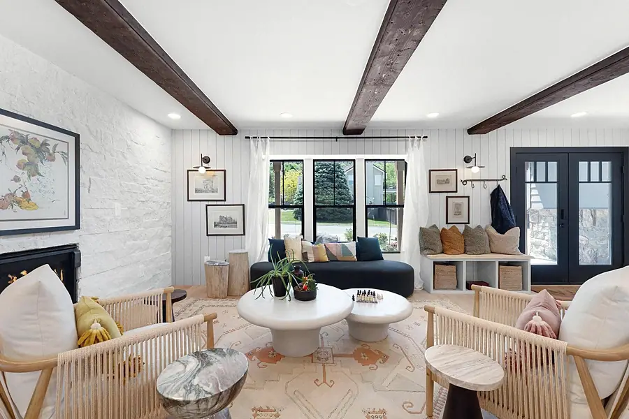 Little Gem living room with white brick fireplace, rope chairs, and entry beyond
