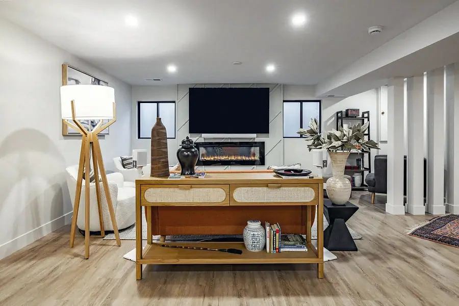 6468 S Brookstone lower living room with console, fireplace TV wall, and tripod lamp