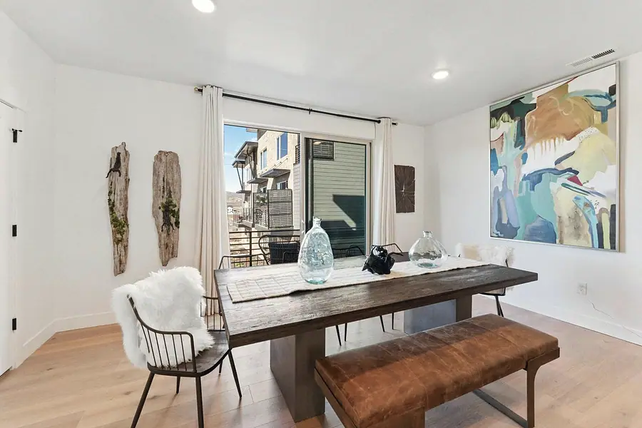 Silver Creek dining room with wood table, leather bench, and abstract art