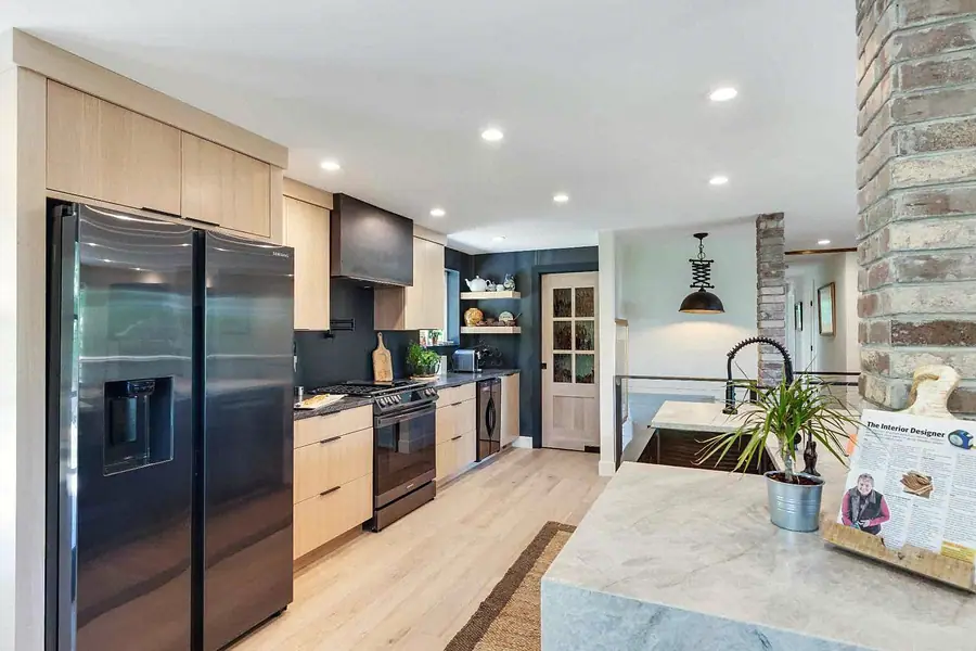 Wallace Project kitchen cooking wall with range, refrigerator, and island