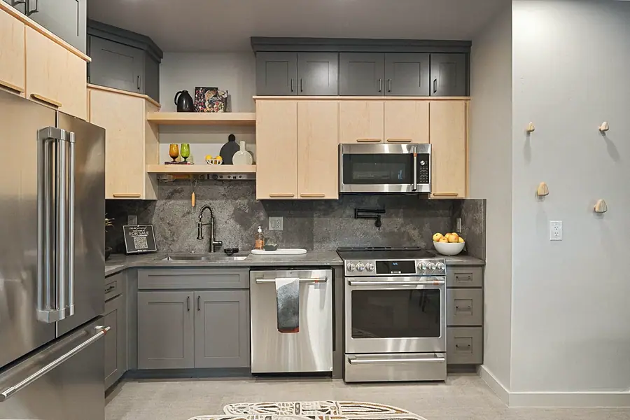 Matterhorn Hygge House kitchen with maple and gray cabinets, stainless appliances, and stone counters