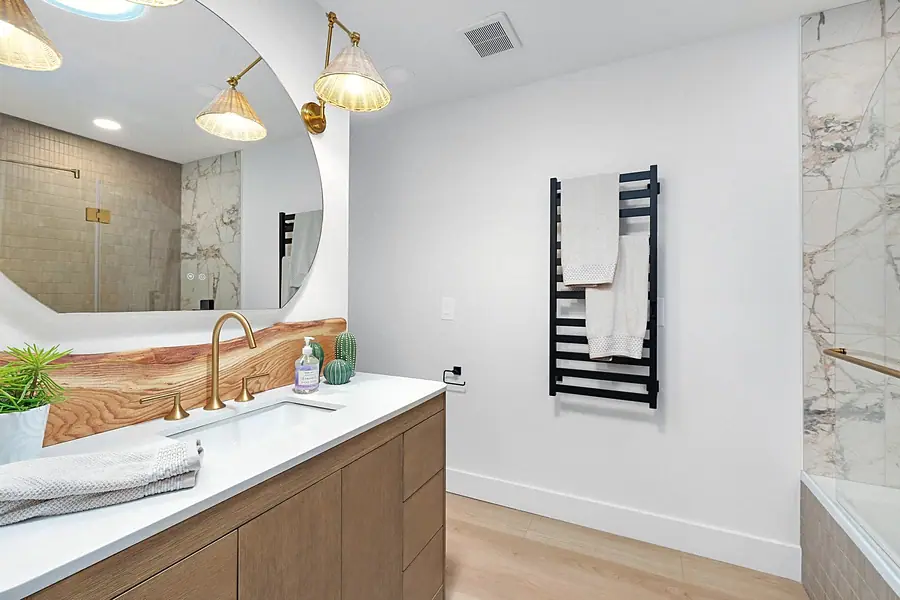Little Gem bathroom vanity with live-edge wood backsplash and brass fixtures