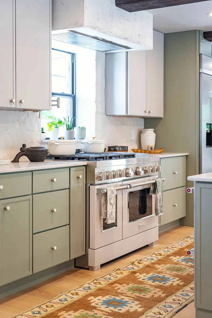 Little Gem professional range with sage cabinetry and marble range hood