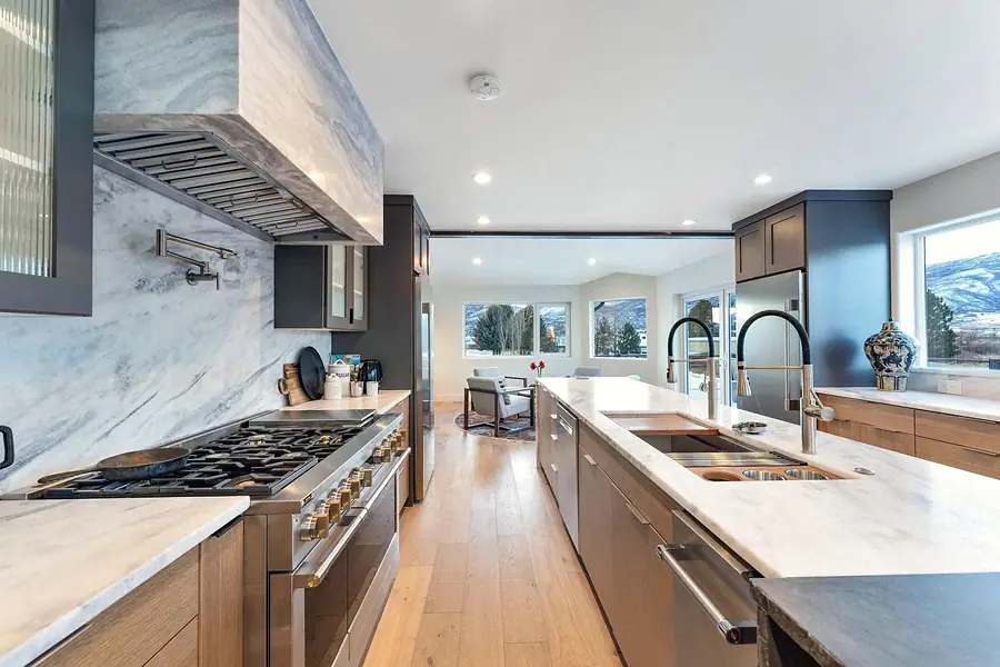 Kitchen range wall with marble backsplash and dual island sinks