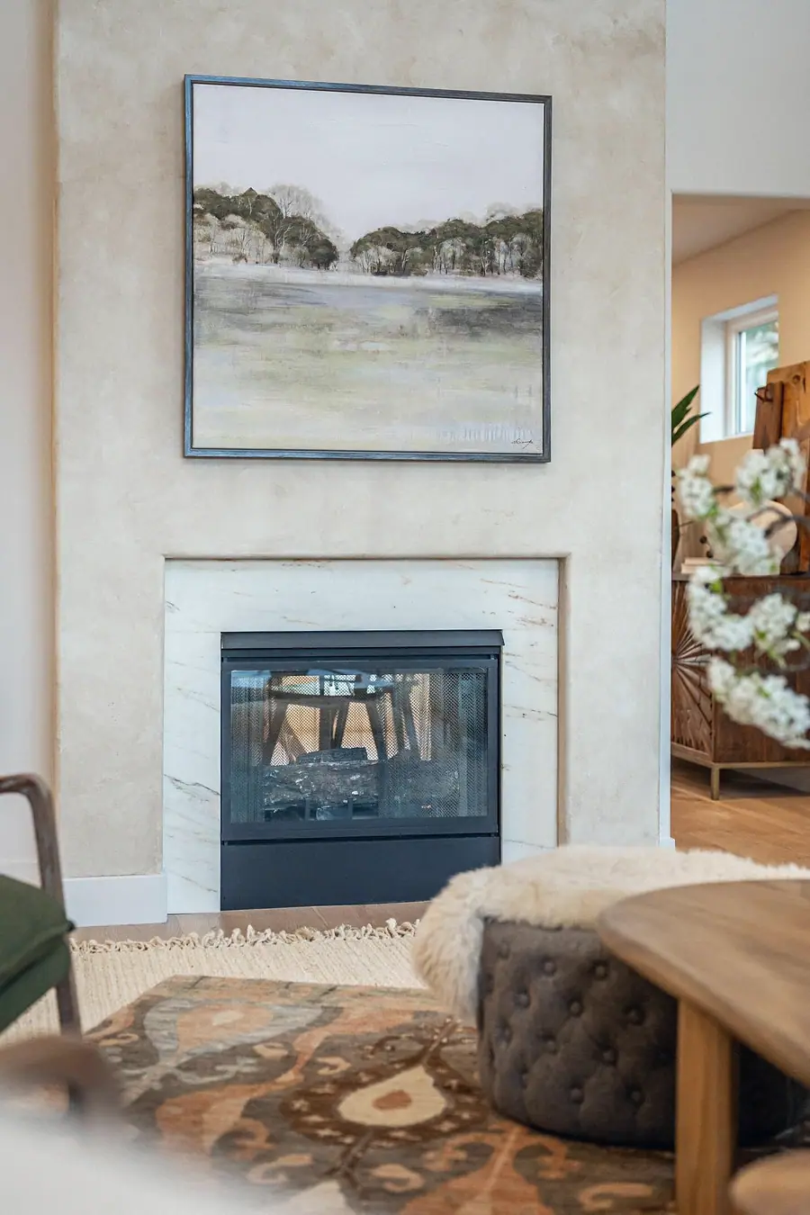 Grand Vista marble fireplace with landscape art above