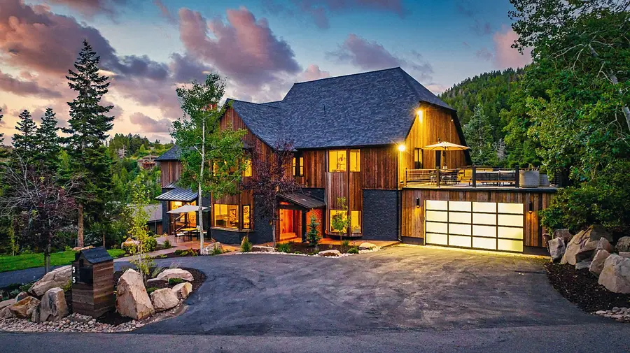 Matterhorn Hygge House garage court and wood exterior at dusk with illuminated glass garage doors