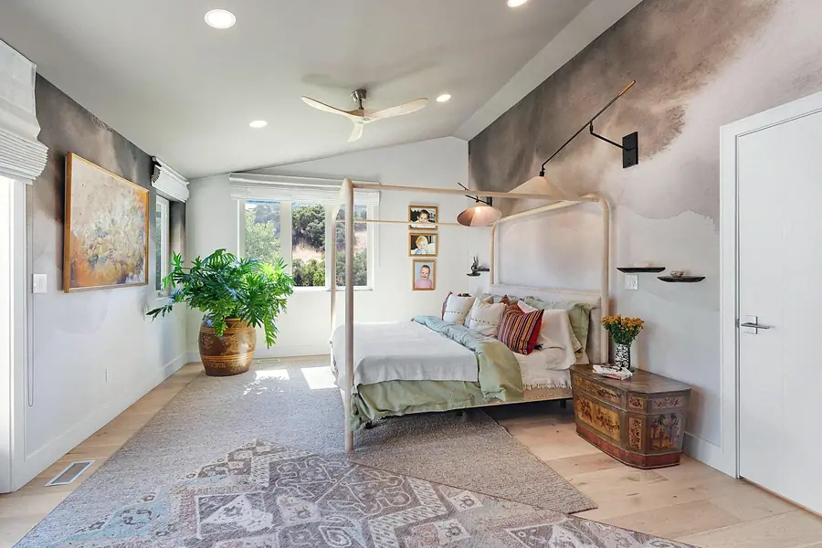 Elysium primary bedroom with watercolor mural walls and four-poster bed