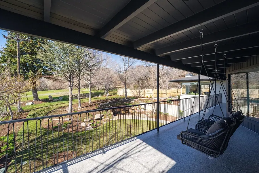 Fairway House covered deck with hanging swing chairs and open bedroom doors