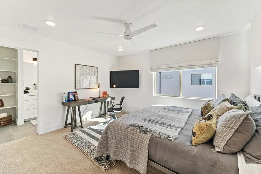 Silver Creek bedroom with desk workspace, wall TV, and en-suite bath beyond