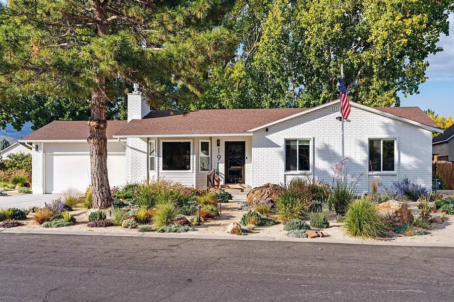 Midway vacation home daytime exterior with pine tree, American flag, and desert landscaping