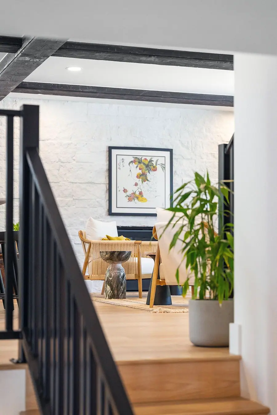 Little Gem living area with white brick wall, rope chairs, and fruit artwork