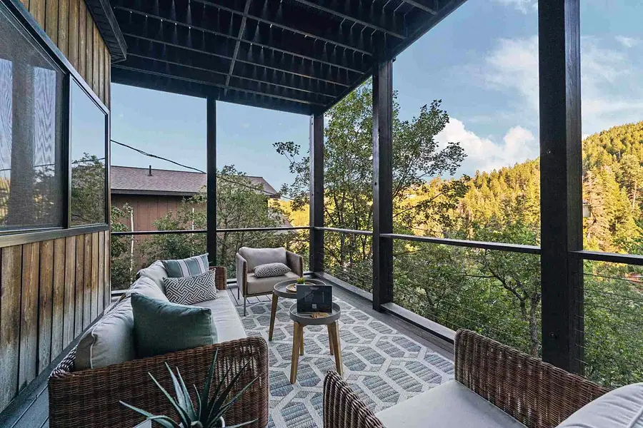 Matterhorn Hygge House outdoor lounge with wicker seating and mountain forest views