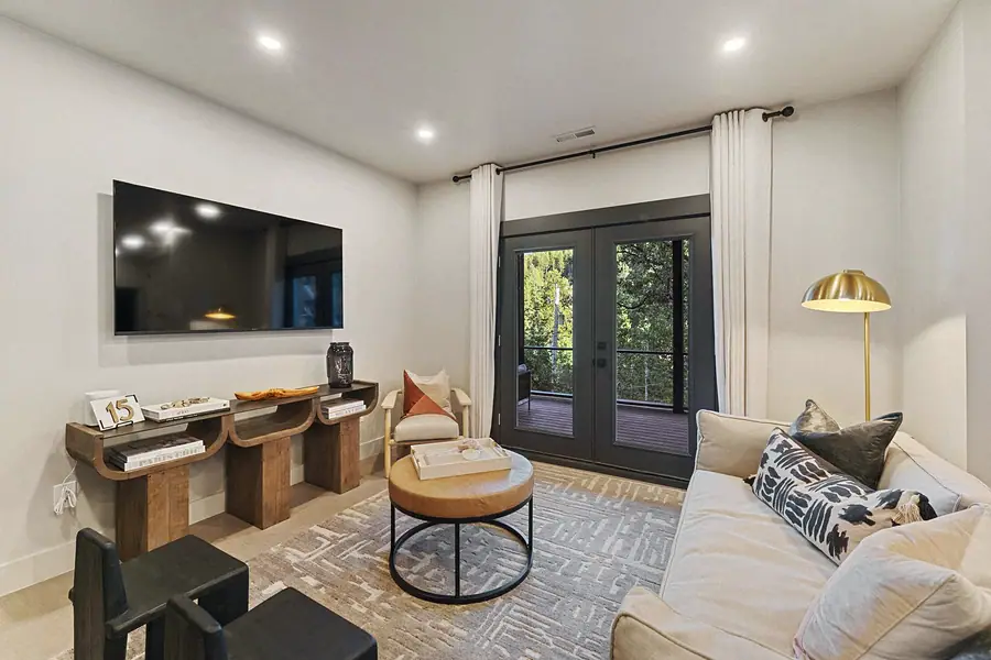 Matterhorn Hygge House living room with wall TV, sculptural console, and French doors to the deck