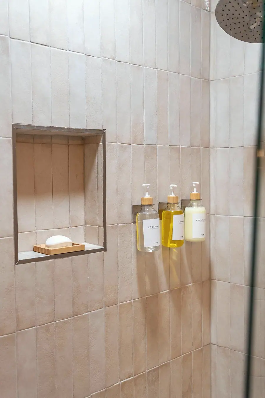 Midway tiled shower with recessed shelf and clear bath product dispensers