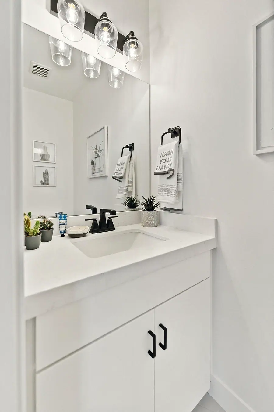Silver Creek powder bath with white vanity, matte black faucet, and wash-your-hands towel